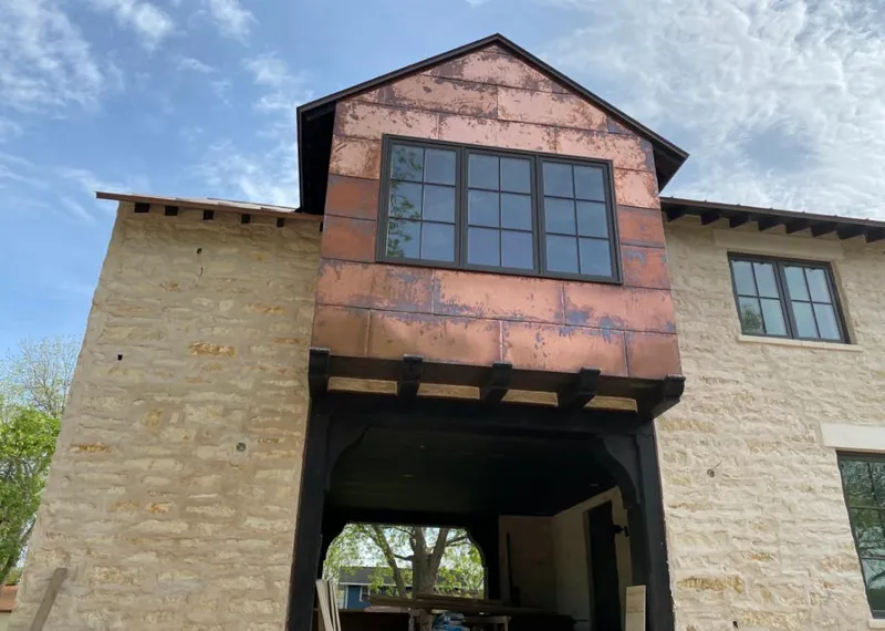 Copper metal panel facade on a stone building for Skylight Installation in Winslow